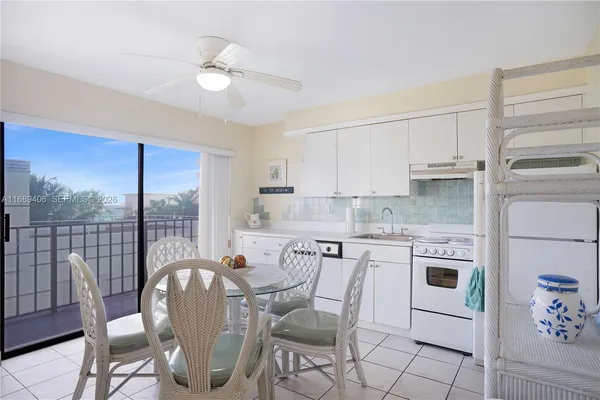 a kitchen with stainless steel appliances granite countertop a stove a refrigerator a white table and chairs