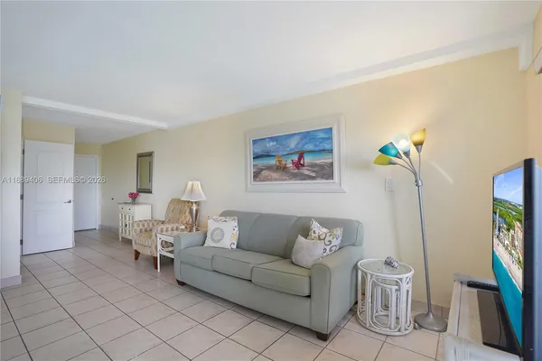 a living room with furniture a wall paintings a piano and a window
