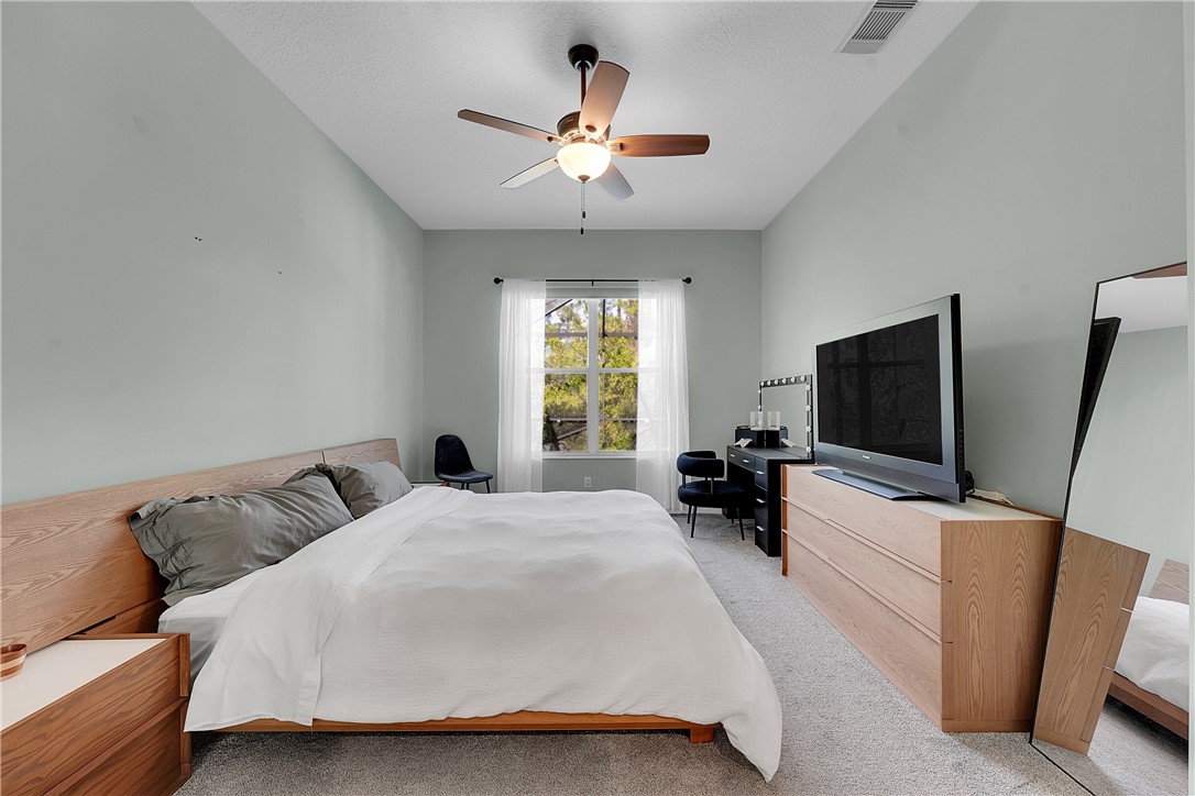 715 Southwest Munjack Circle Port St. Lucie, FL 34986 - Photo 15 of 36 a bedroom with a bed and flat screen tv