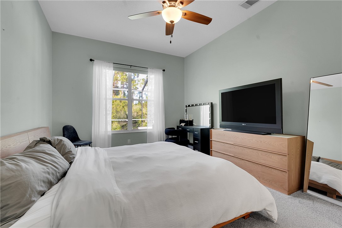 715 Southwest Munjack Circle Port St. Lucie, FL 34986 - Photo 16 of 36 a bedroom with a bed and a flat screen tv