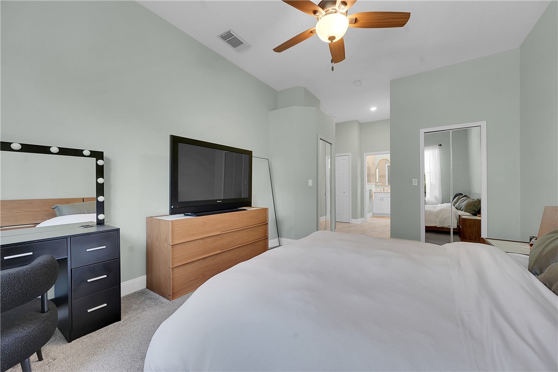 715 Southwest Munjack Circle Port St. Lucie, FL 34986 - Photo 17 of 36 a bedroom with a bed and a chandelier