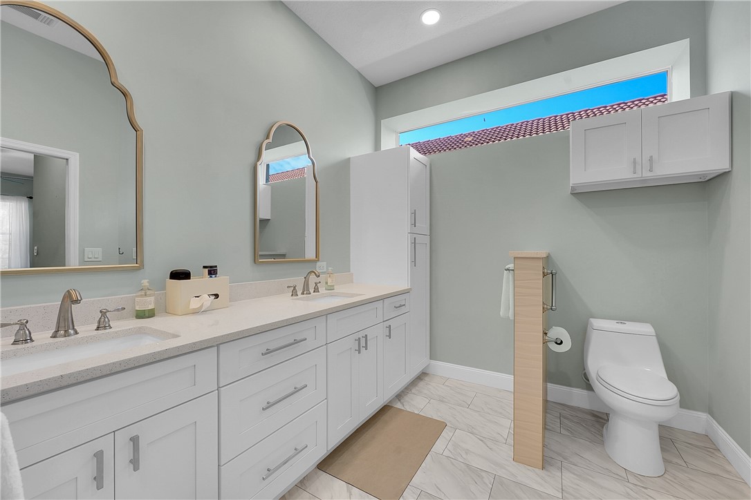 715 Southwest Munjack Circle Port St. Lucie, FL 34986 - Photo 19 of 36 a spacious bathroom with a toilet sink and mirror