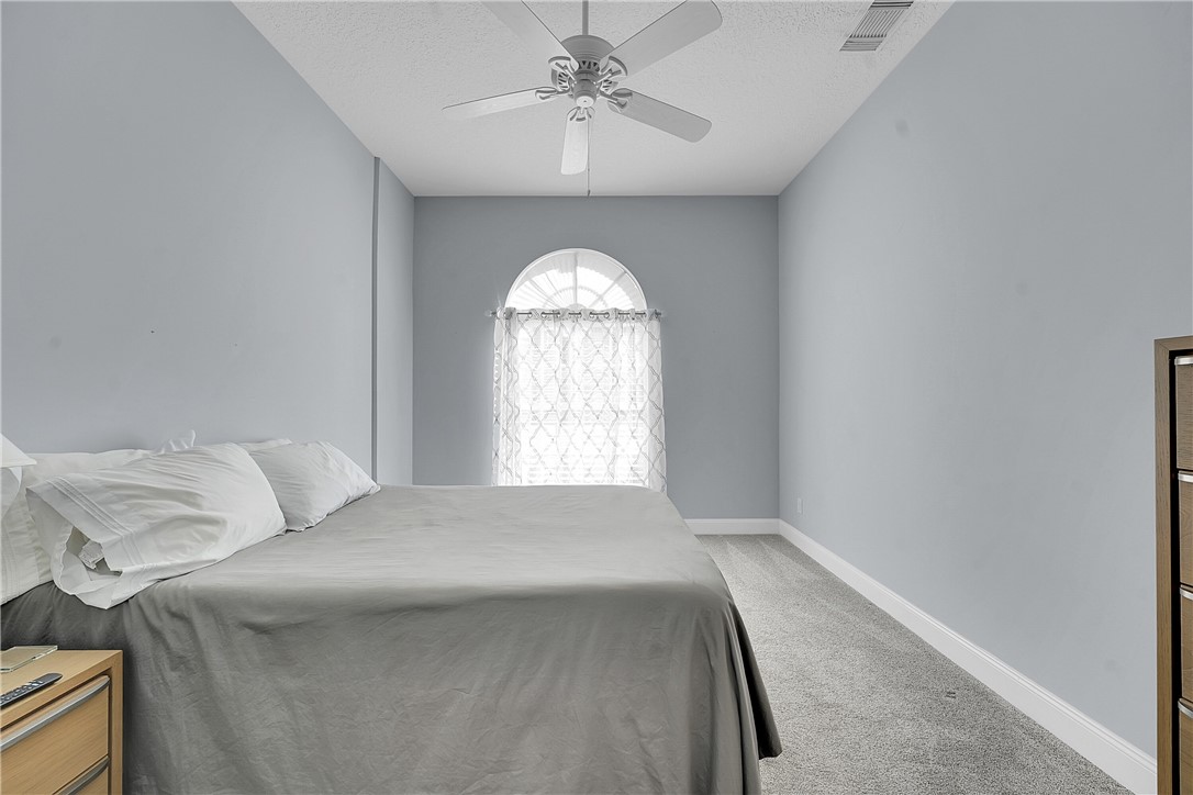 715 Southwest Munjack Circle Port St. Lucie, FL 34986 - Photo 20 of 36 a bed room with a bed and a chandelier