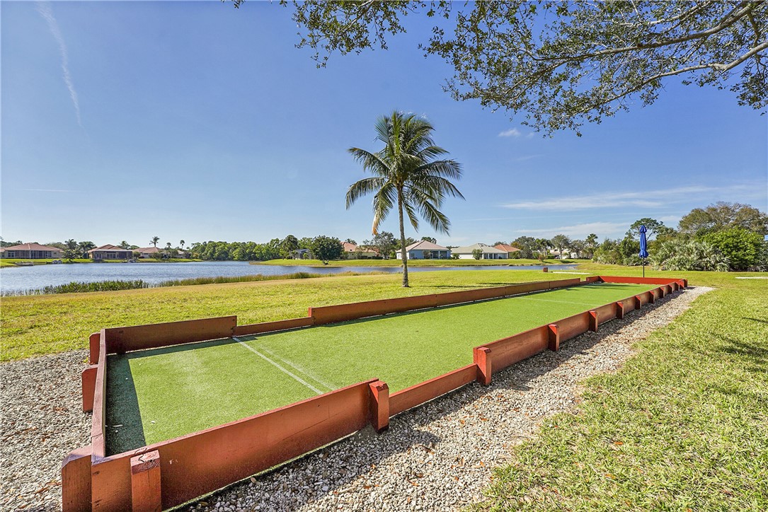 715 Southwest Munjack Circle Port St. Lucie, FL 34986 - Photo 34 of 36 a view of a swimming pool with a lawn chairs under an umbrella