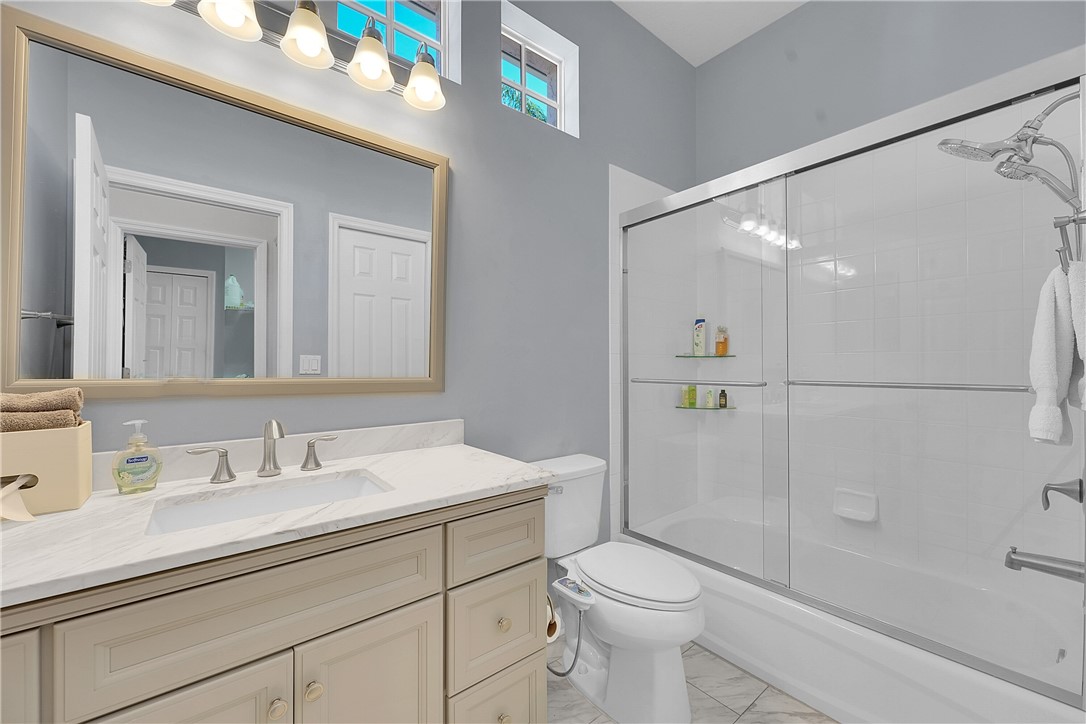 715 Southwest Munjack Circle Port St. Lucie, FL 34986 - Photo 6 of 36 a bathroom with a sink a toilet and shower