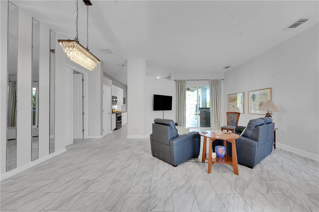 715 Southwest Munjack Circle Port St. Lucie, FL 34986 - Photo 9 of 36 a living room with furniture and a flat screen tv