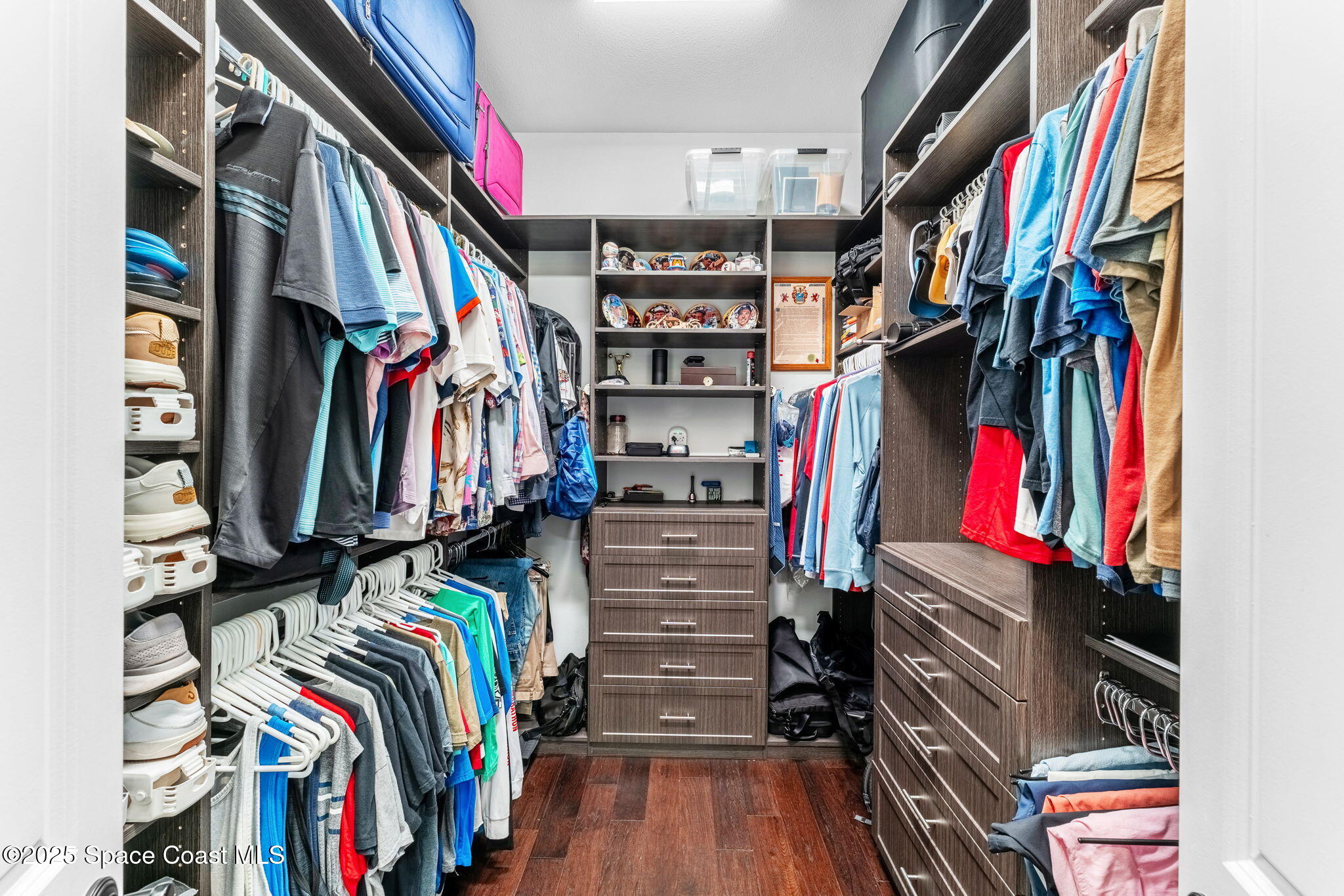4655 Tea Tree Court Rockledge, FL 32955 - Photo 16 of 58 a view of walk in closet with clothes and shoes