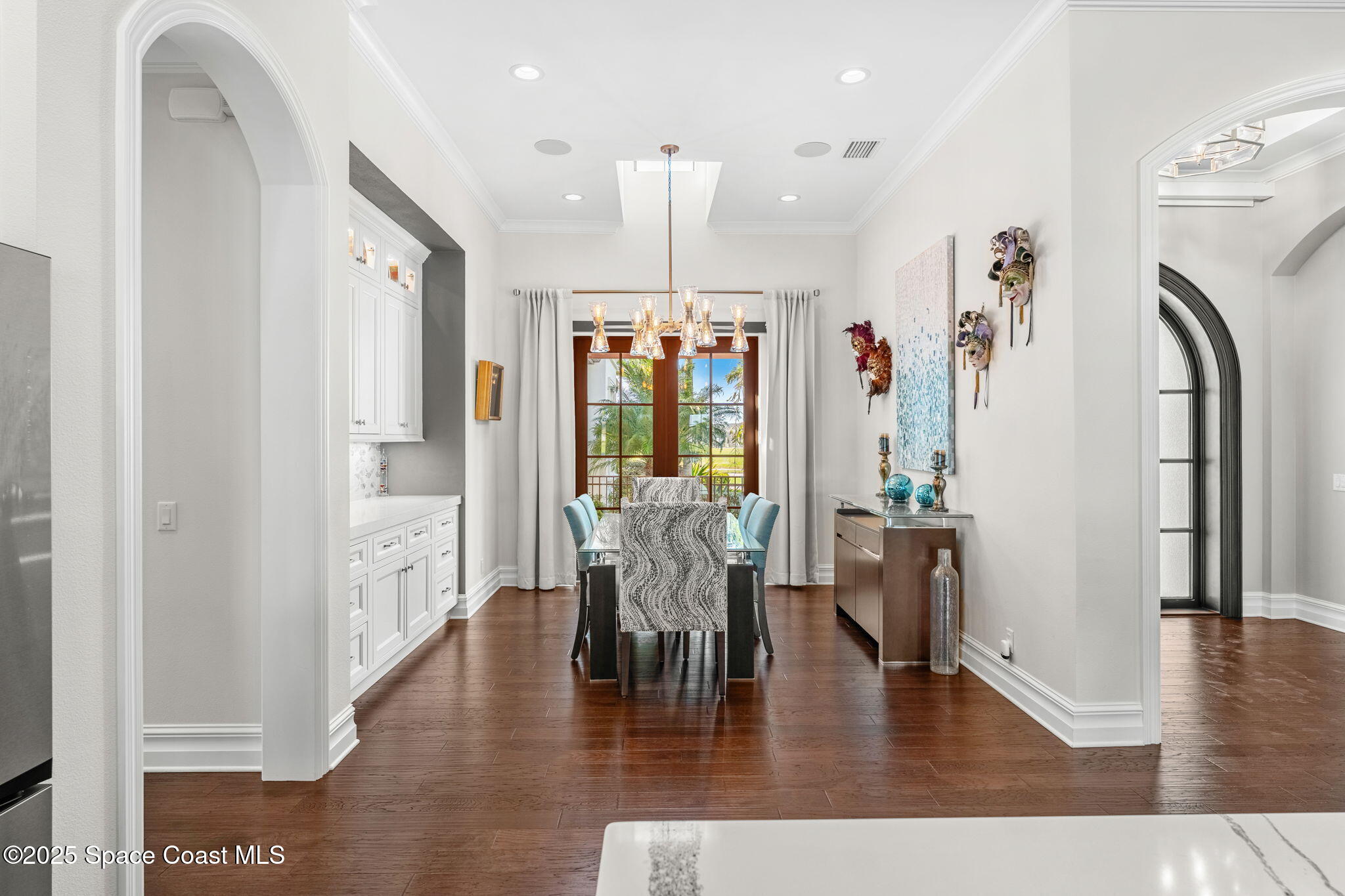 4655 Tea Tree Court Rockledge, FL 32955 - Photo 21 of 58 a dining room with wooden floor a chandelier a glass table and chairs