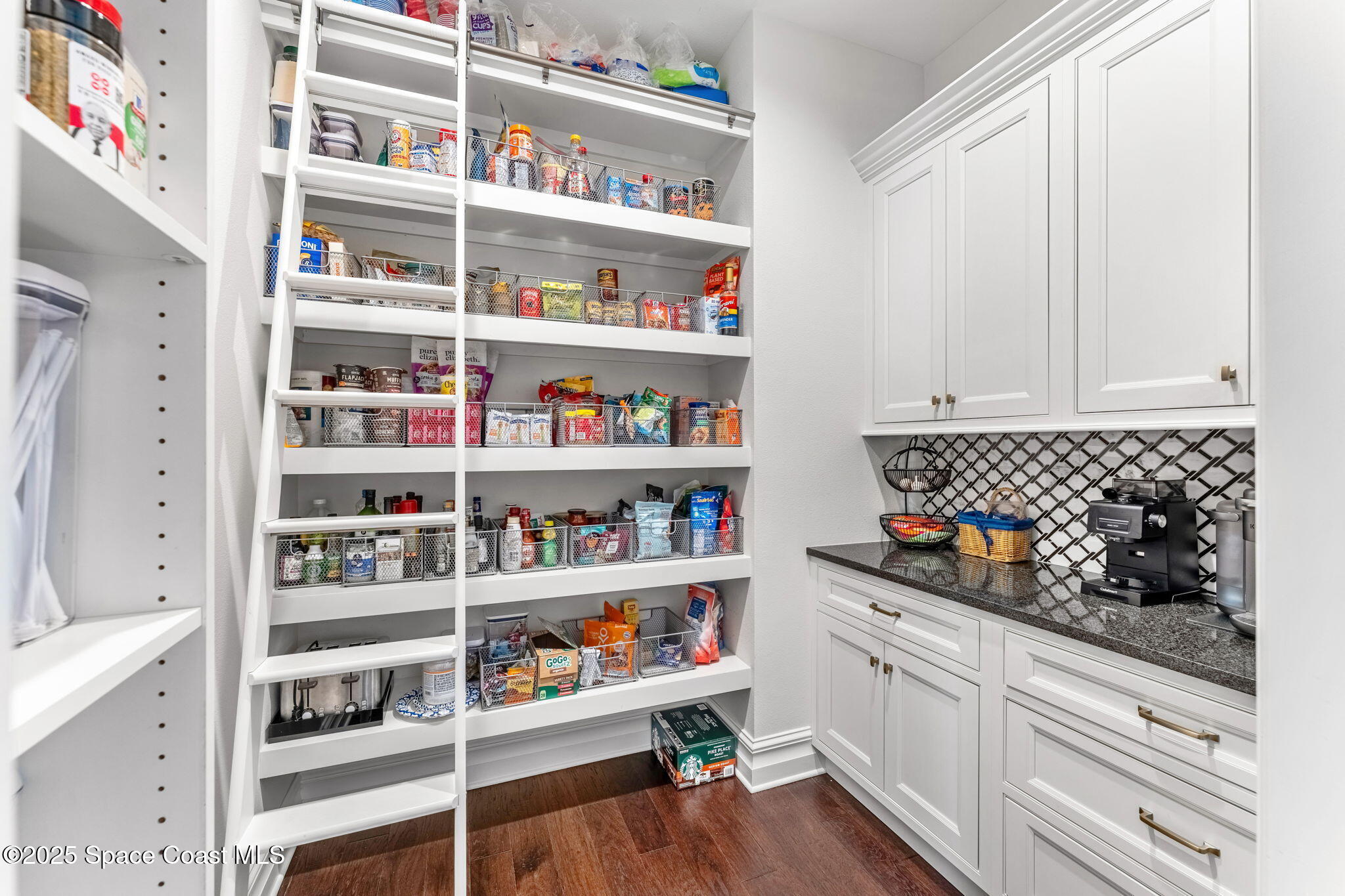 4655 Tea Tree Court Rockledge, FL 32955 - Photo 33 of 58 a kitchen with white cabinets and wooden floor