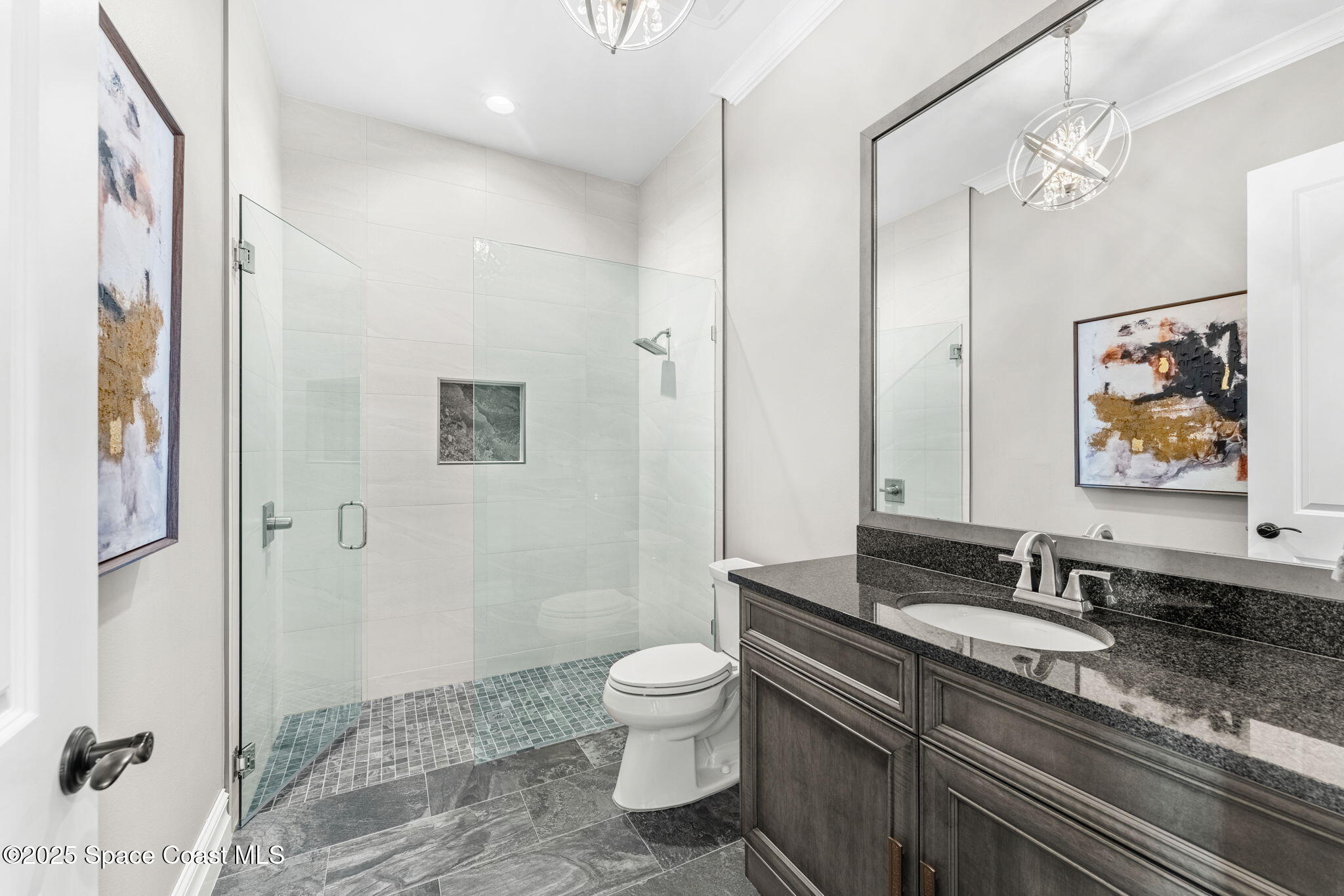 4655 Tea Tree Court Rockledge, FL 32955 - Photo 37 of 58 a spacious bathroom with a granite countertop sink toilet a mirror a vanity and shower