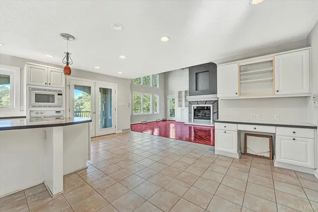 an empty room with windows and ceiling fan