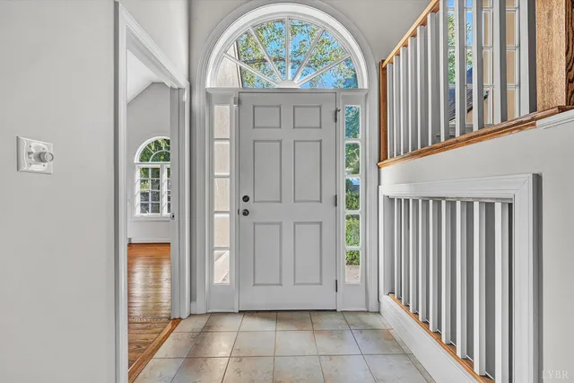 a view of an empty room with wooden floor fireplace and a window