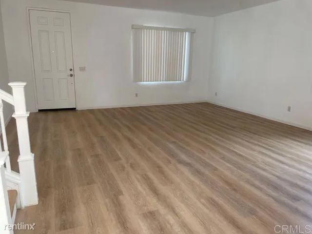 a view of a room with wooden floor and cabinet