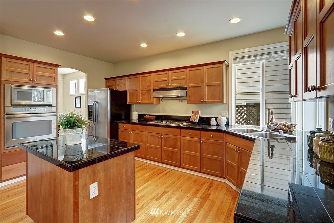 4202 Northeast 27th Place Renton, WA 98059 - Photo 8 of 29 a kitchen with stainless steel appliances granite countertop a stove a sink and a refrigerator