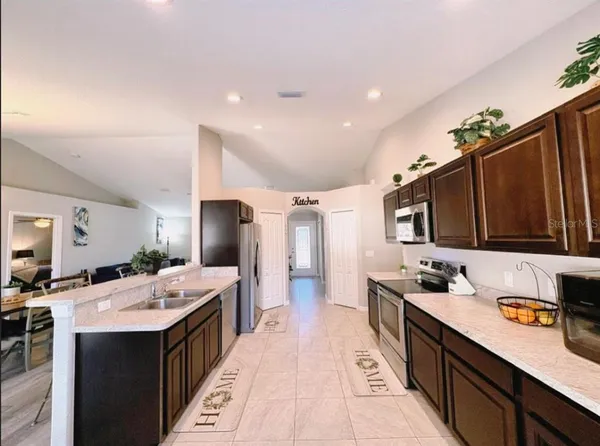 a large kitchen with kitchen island a sink stainless steel appliances and cabinets