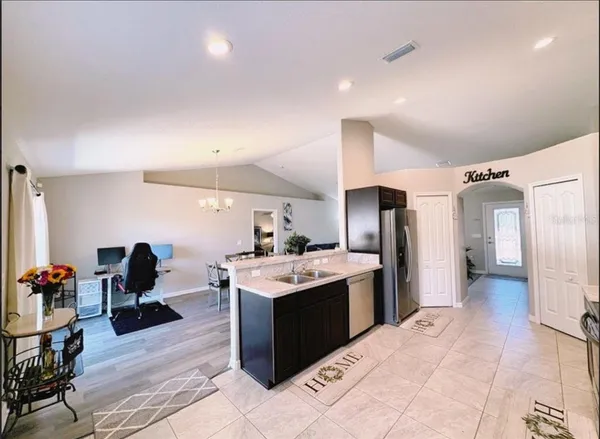 a kitchen with stainless steel appliances kitchen island granite countertop a refrigerator and a stove top oven