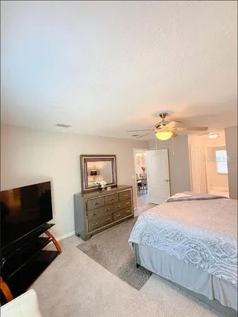 a spacious bedroom with a bed a dresser and a window