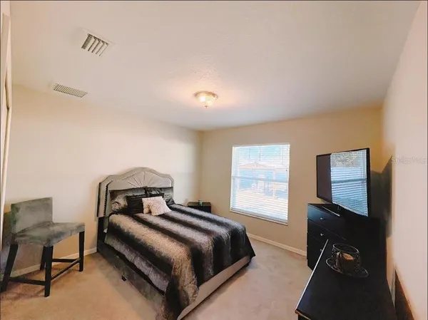 a bedroom with two beds and a computer on a desk next to a window