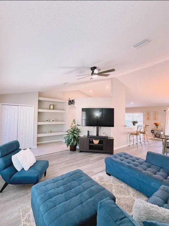 12365 Indigo Bunting Road Weeki Wachee, FL 34614 - Photo 8 of 39 a living room with furniture and a flat screen tv