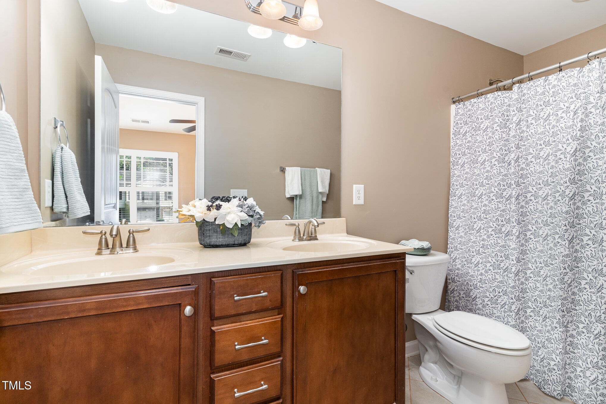 4732 Altha Street Raleigh, NC 27606 - Photo 12 of 23 a bathroom with a double vanity sink toilet and a mirror