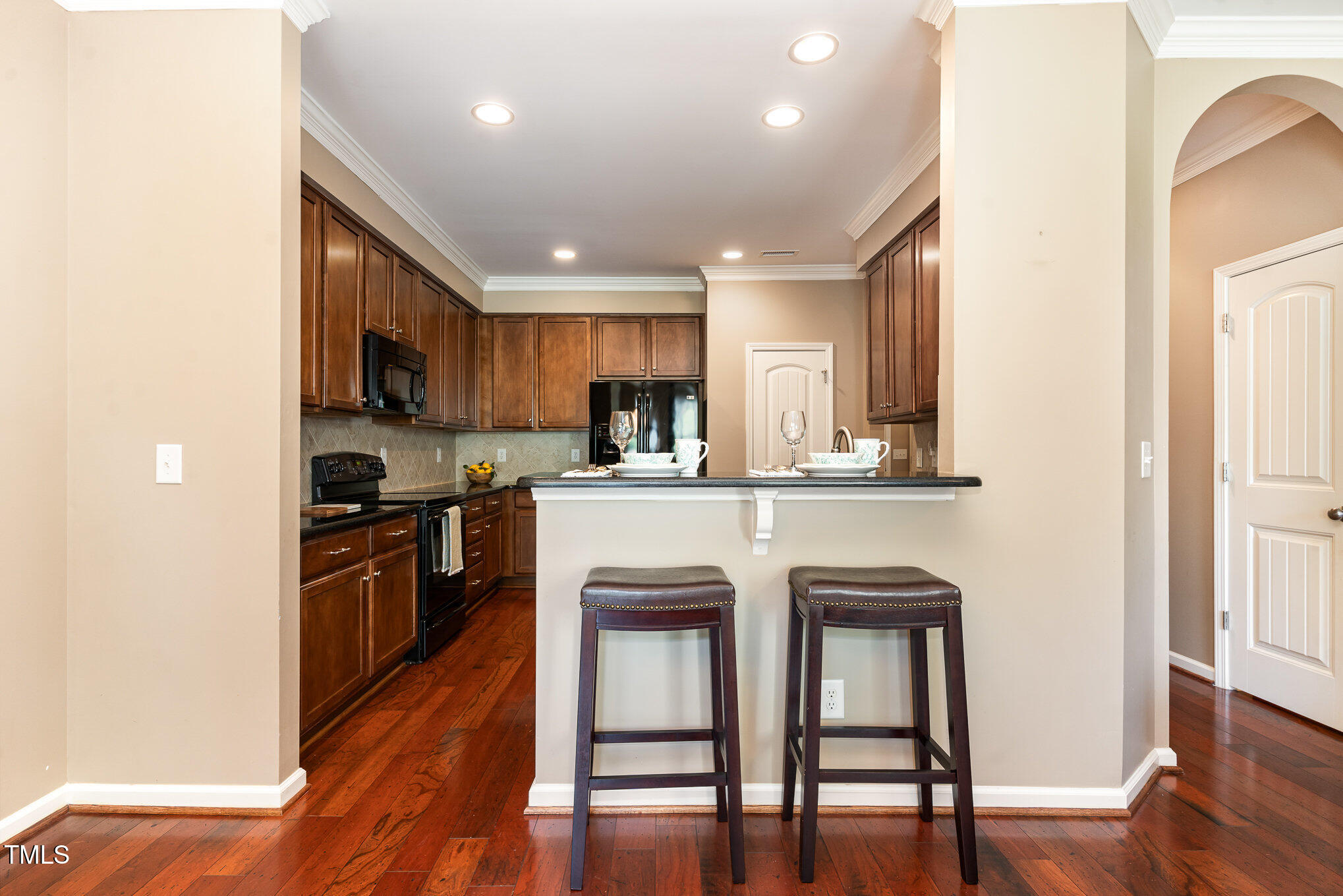 4732 Altha Street Raleigh, NC 27606 - Photo 6 of 23 a kitchen with kitchen island granite countertop wooden floors and stainless steel appliances
