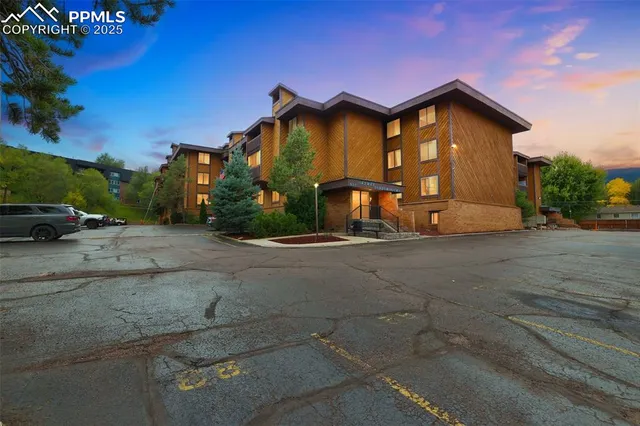 a view of a house with a yard and parking space