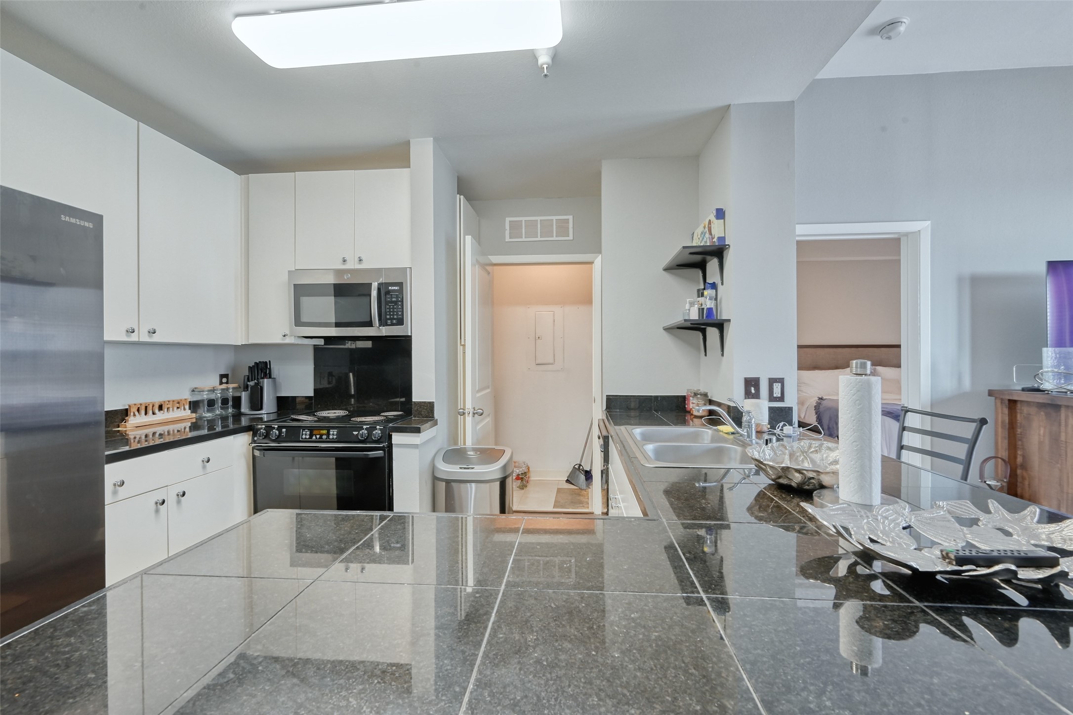 3505 Sage Road, Unit 1206 Houston, TX 77056 - Photo 26 of 50 a kitchen with stainless steel appliances kitchen island granite countertop a stove top oven a sink a dining table and chairs