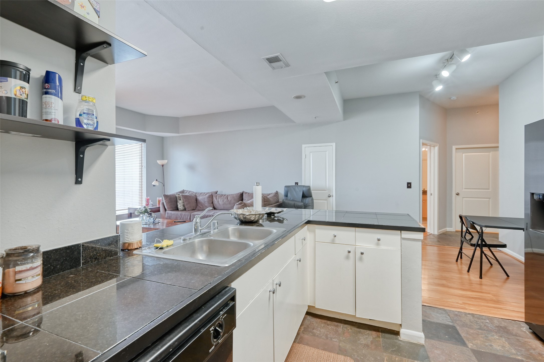 3505 Sage Road, Unit 1206 Houston, TX 77056 - Photo 31 of 50 a kitchen with a sink dishwasher and white cabinets with wooden floor