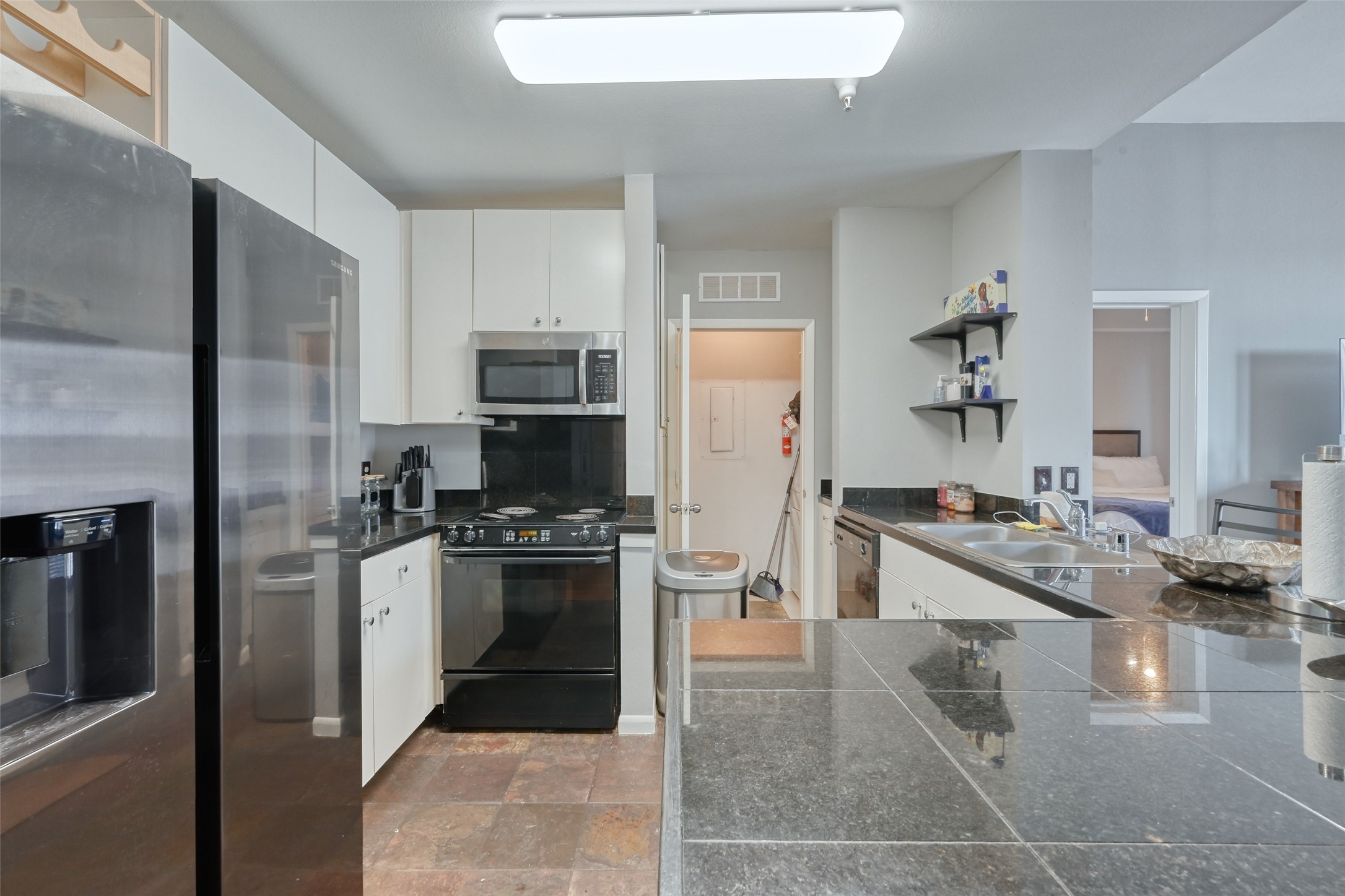 3505 Sage Road, Unit 1206 Houston, TX 77056 - Photo 32 of 50 a kitchen with stainless steel appliances granite countertop a refrigerator and a stove
