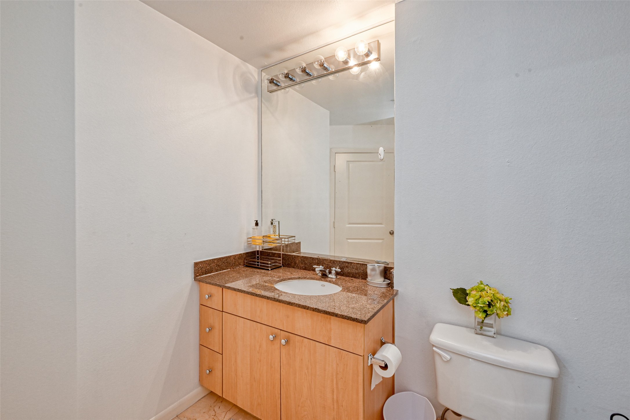 3505 Sage Road, Unit 1206 Houston, TX 77056 - Photo 34 of 50 a bathroom with a granite countertop sink a toilet and a mirror
