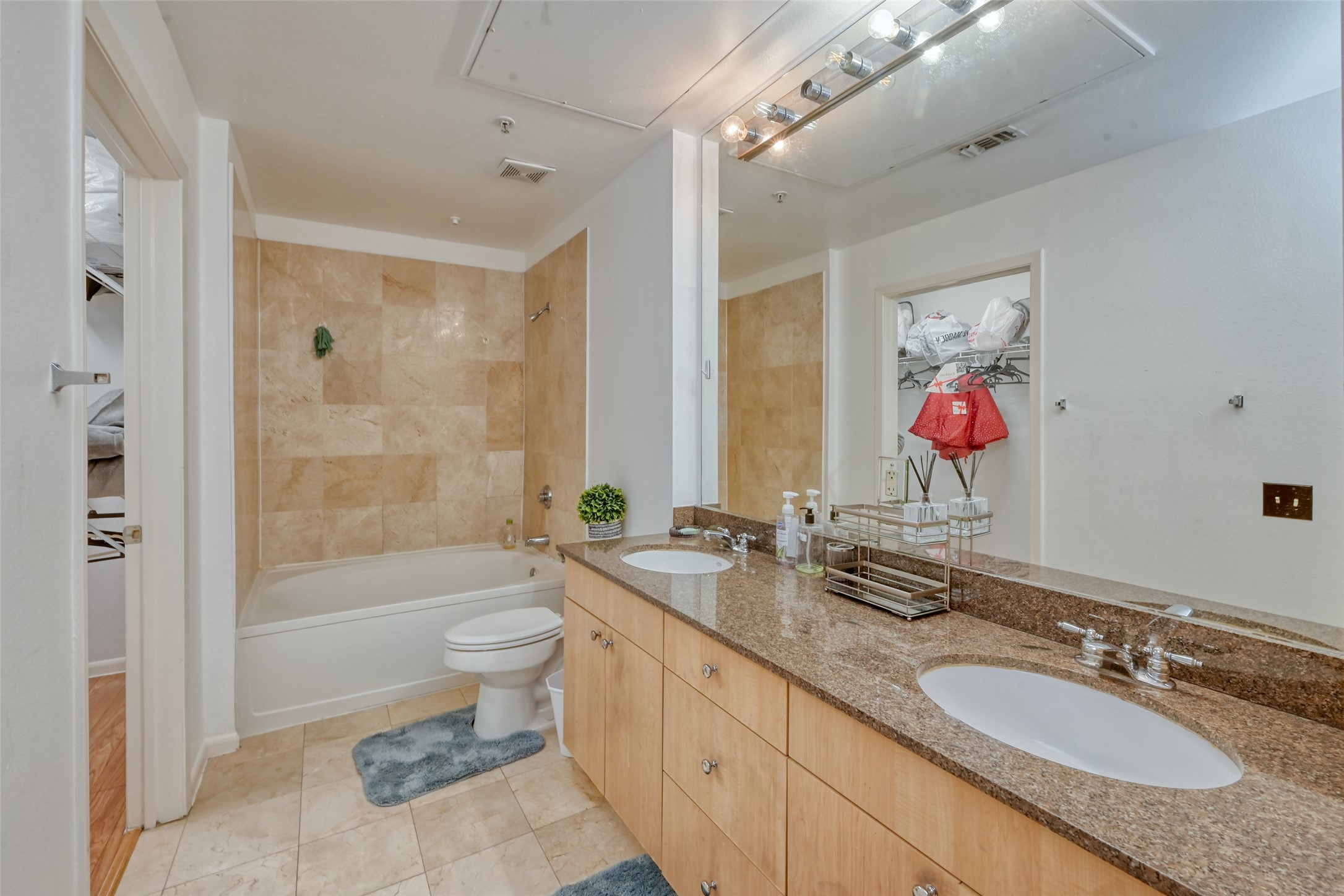 3505 Sage Road, Unit 1206 Houston, TX 77056 - Photo 40 of 50 a bathroom with a granite countertop double vanity sink a mirror a bathtub and a toilet