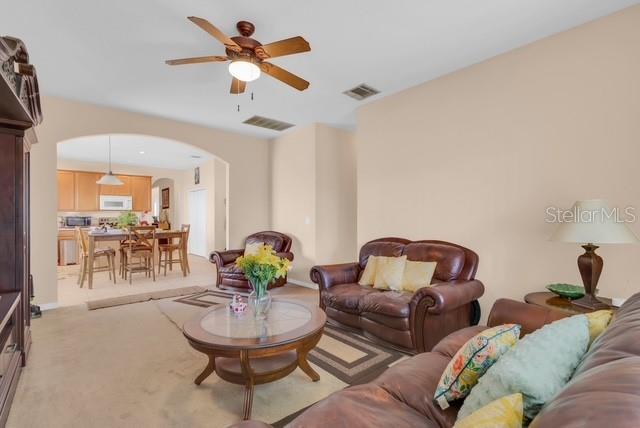 5120 Shale Ridge Trail Orlando, FL 32818 - Photo 4 of 15 a living room with furniture a rug and a chandelier