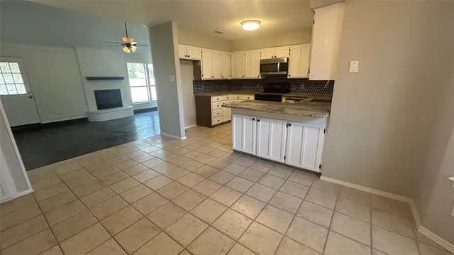 a kitchen with granite countertop a stove a sink and a refrigerator
