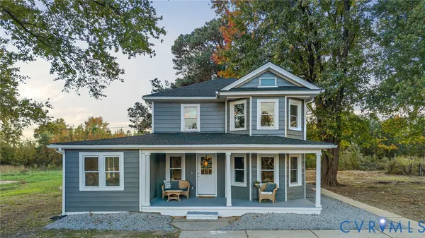 a front view of a house with yard and trees around