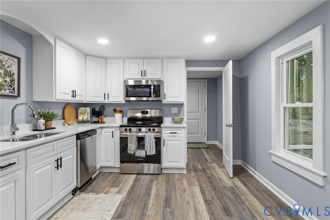 7946 Howerton Road Dunnsville, VA 22454 - Photo 12 of 47 a kitchen with stainless steel appliances granite countertop a stove top oven a sink dishwasher and a refrigerator with wooden floor