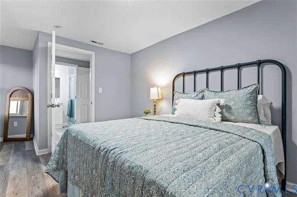 a bedroom with a bed and wooden floor