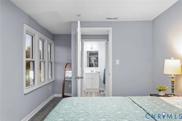 a bedroom with a bed mirror and window