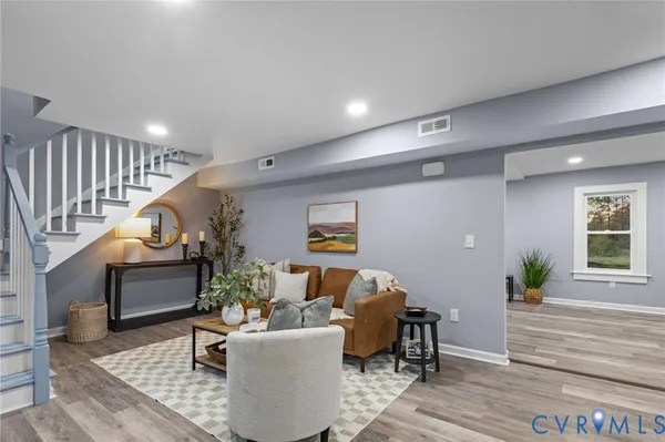 a living room with furniture and a wooden floor