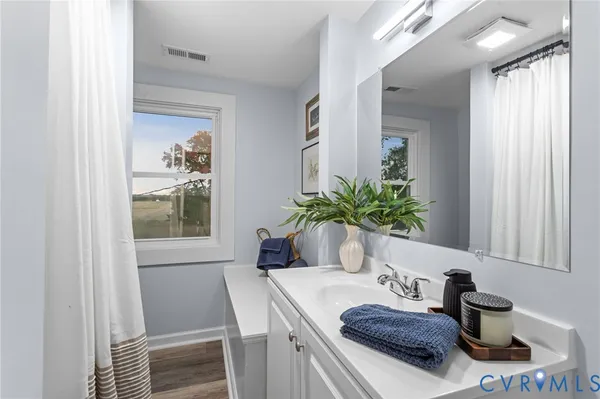 a bathroom with a granite countertop sink a mirror and a shower
