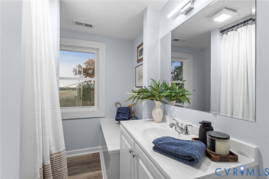 7946 Howerton Road Dunnsville, VA 22454 - Photo 28 of 47 a bathroom with a granite countertop sink a mirror and a shower