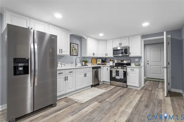 a kitchen with a refrigerator a sink and a stove top oven