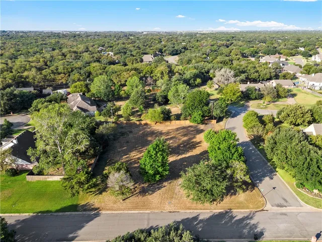 an aerial view of residential houses with outdoor space and trees
