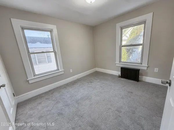 an empty room with windows and closet
