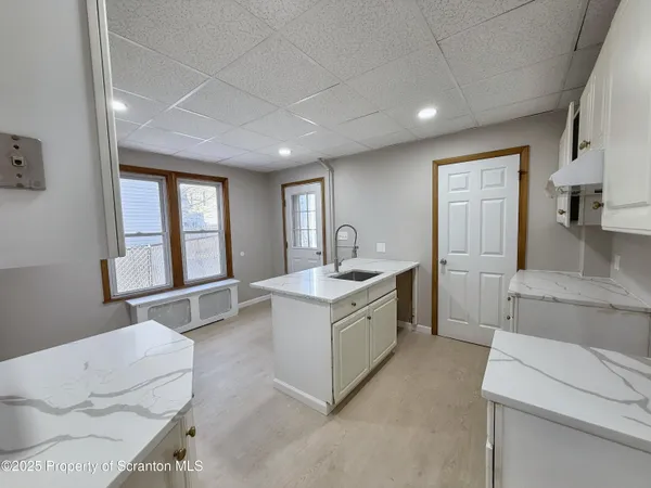 a large white kitchen with sink and white cabinets