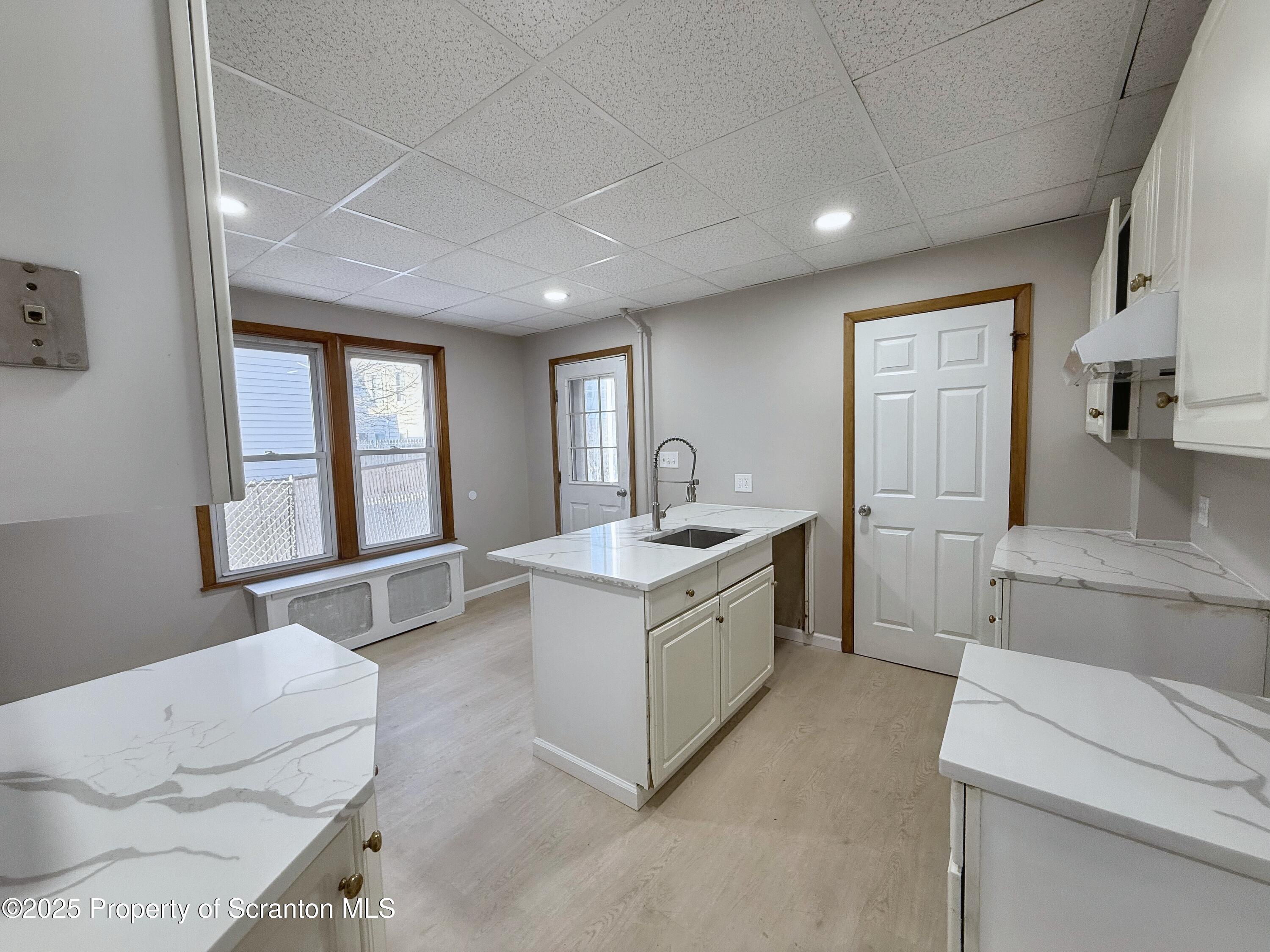 1513 15 Myrtle Street Scranton, PA 18510 - Photo 3 of 22 a large white kitchen with sink and white cabinets