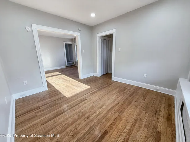 a view of an empty room and wooden floor