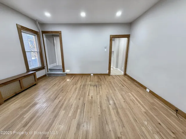 a view of empty room with wooden floor