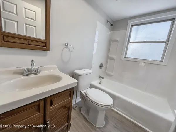 a bathroom with a sink toilet vanity and bathtub
