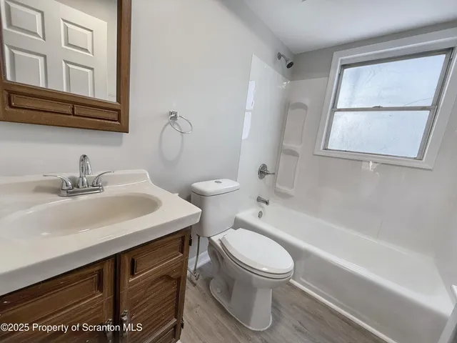 a bathroom with a sink toilet vanity and bathtub