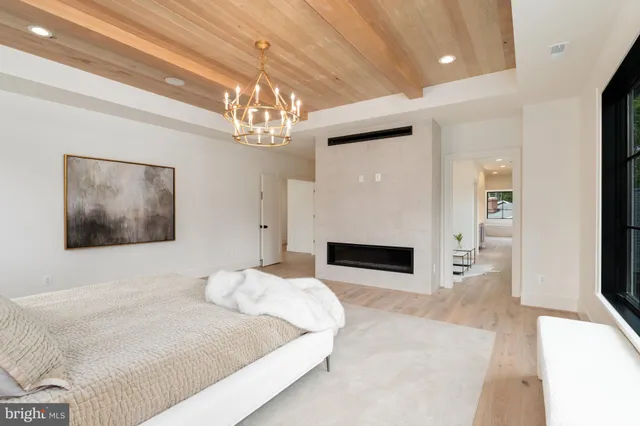 a bedroom with a large bed a chandelier and fireplace